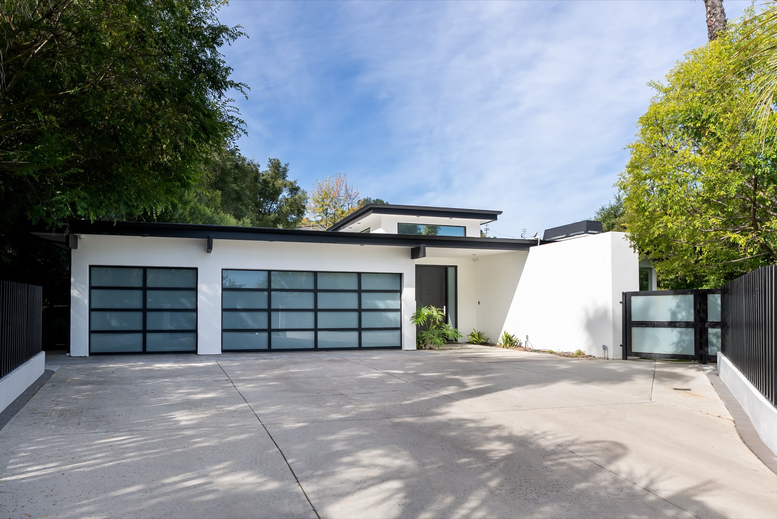 The gated motor court and modern white facade of 3371 Alana Drive in Sherman Oaks